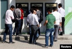 People line in front of automated teller machines (ATMs) in Hatay, May 17, 2013.