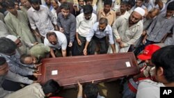 Relatives and colleague carry the casket of Pakistani journalist Saleem Shahzad for burial at a graveyard after funeral prayers in Karachi, June 1, 2011.