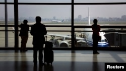 FILE - Passengers wait to board their plane at Shanghai's Hongqiao International Airport.