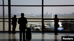 FILE - Passengers wait to board their plane at Shanghai's Hongqiao International Airport.