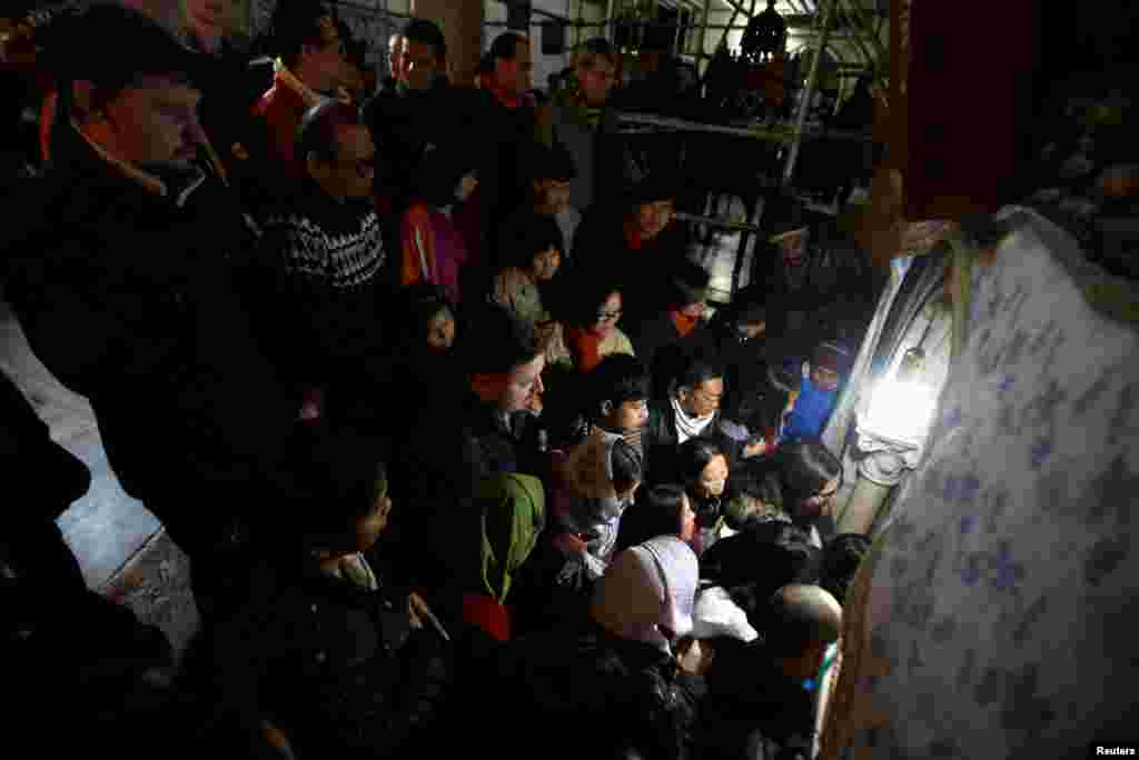 Visitors wait to get inside the cave, where Virgin Mary is believed to have given birth to Jesus, on Christmas, inside the Church of the Nativity in the West Bank town of Bethlehem, Dec. 25, 2016.