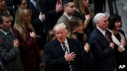 President Donald Trump signs the National Anthem during a National Prayer Service at the National Cathedral, in Washington, Jan. 21, 2017. 