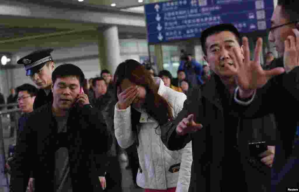 Thân nhân của hành khách trên chuyến bay của hãng hàng không Malaysia MH370 bị mất tích ôm mặt khóc tại sân bay quốc tế Bắc Kinh, ngày 8/3/2014.