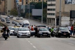 Taxi drivers block a main highway with their vehicles during a protest against the increasing prices of gasoline, consumer goods and the crash of the local currency, in Beirut, Lebanon, Nov. 30, 2021.