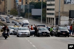 Taxi drivers block a main highway with their vehicles during a protest against the increasing prices of gasoline, consumer goods and the crash of the local currency, in Beirut, Lebanon, Nov. 30, 2021.