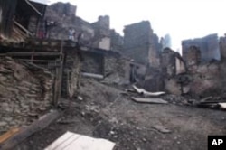 People amidst debris of burnt houses in the settlement of Tsibari in Russia's republic of Dagestan in North Caucasus where 80 percent of the village buildings were destroyed by fire.