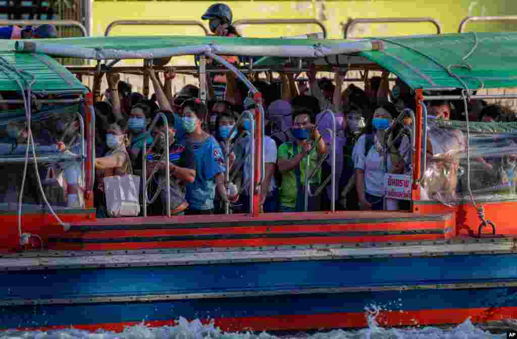 Passengers wearing face masks ride a canal boat during the evening rush hour in Bangkok, Thailand.