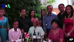 The family celebrates their reunion with friends at a party in Phnom Penh, Cambodia. 