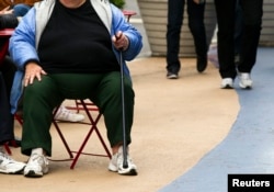 Seorang perempuan dengan berat badan berlebih sedang duduk di Times Square, New York, 8 Mei 2012.