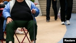FILE - An overweight woman sits on a chair in Times Square, New York.