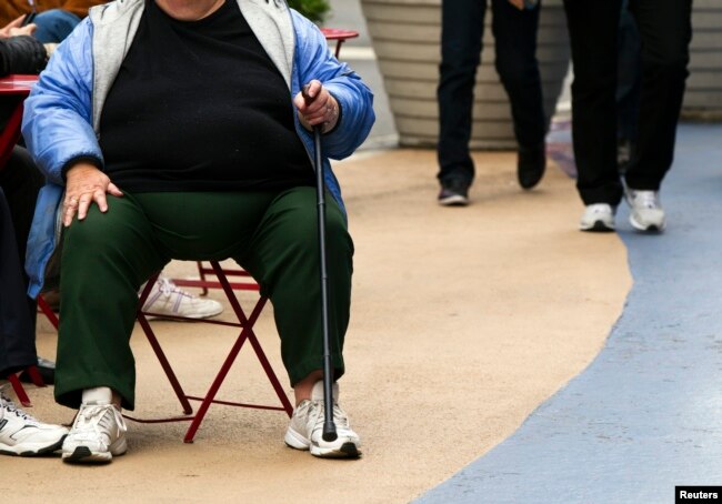 Seorang perempuan dengan berat badan berlebih sedang duduk di Times Square, New York, 8 Mei 2012.