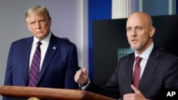 President Donald Trump listens as Dr. Stephen Hahn, commissioner of the U.S. Food and Drug Administration, speaks during a media briefing in the James Brady Briefing Room of the White House, Aug. 23, 2020, in Washington.