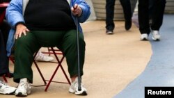 FILE - An overweight woman sits on a chair in Times Square in New York, May 8, 2012. In 2015, excess weight affected 2.2 billion people, equal to 30 percent of the world's population, according to a new study. 