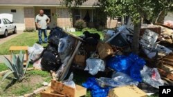 Salvador Cortez, 58, shows debris in the front yard of his home in Houston, Texas, Sept. 9, 2017. Unable to afford an alternative and awaiting a solution from the Federal Emergency Management Agency, he is sleeping in his musty, flood-gutted home.