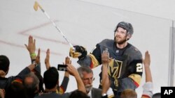 Vegas Golden Knights defenseman Shea Theodore gives his stick to fans after the Knights defeated the Washington Capitals 6-4 in Game 1 of the NHL hockey Stanley Cup Finals Monday, May 28, 2018, in Las Vegas. (AP Photo/Ross D. Franklin)