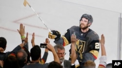Vegas Golden Knights defenseman Shea Theodore gives his stick to fans after the Knights defeated the Washington Capitals 6-4 in Game 1 of the NHL hockey Stanley Cup Finals Monday, May 28, 2018, in Las Vegas.