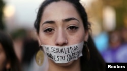 A woman covers her mouth with a tape that reads "My sexuality is not your conjugal right" during a demonstration to support International Day for the Elimination of Violence Against Women in Santiago, Chile, Nov. 25, 2016.