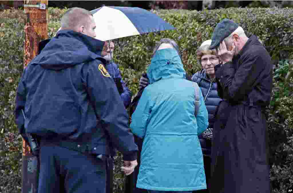 People gather on a corner near the Tree of Life Synagogue in Pittsburgh, Pennsylavania, where a shooter opened fire Oct. 27, 2018.