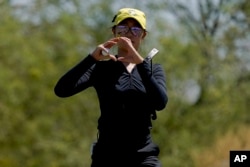 Oregon golfer Tze-Han Lin gestures to teammates on the first green during the NCAA college women's golf championship title match against Stanford, at Grayhawk Golf Club in Scottsdale, Ariz., Wednesday, May 25, 2022. Tze-Han Lin, like many other international athletes playing college sports in the United States, had little sense of Title IX when they were teenagers. But the federal law has opened the door for thousands of female athletes to get an American education and a shot at a career. (AP Photo/Matt York, File)