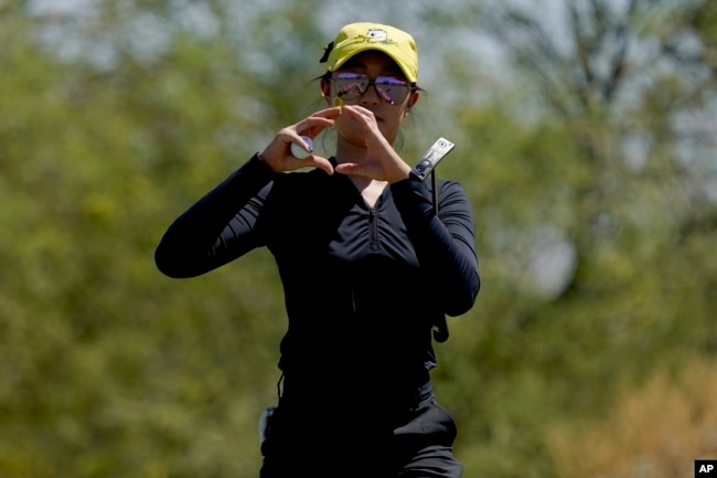 Oregon golfer Tze-Han Lin gestures to teammates on the first green during the NCAA college women's golf championship title match against Stanford, at Grayhawk Golf Club in Scottsdale, Ariz., Wednesday, May 25, 2022. Tze-Han Lin, like many other international athletes playing college sports in the United States, had little sense of Title IX when they were teenagers. But the federal law has opened the door for thousands of female athletes to get an American education and a shot at a career. (AP Photo/Matt York, File)