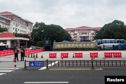 Police officers keep watch near an entrance to the Wuxi Vocational College of Arts and Technology following a knife attack in Wuxi, Jiangsu province, China, on Nov. 17, 2024.