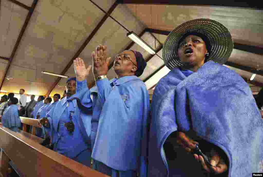 Women reflect and say a prayer for the late former South African President Nelson Mandela at the Regina Mundi Church in Soweto, Dec. 8, 2013. 