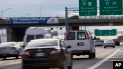 A banner hangs on an overpass on I-395 advertising the new I-95 Express Lanes in Alexandria, Va, Wednesday, Dec. 10, 2014. (AP Photo/Molly Riley)