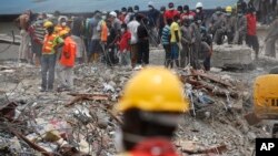 Des employés cherchent des survivants après l’effondrement d’un immeuble à Lagos, Nigeria, septembre 2014. Image : AP