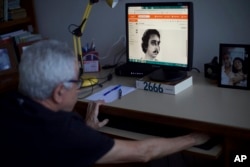 Alvaro Caldas, who was tortured during the dictatorship, shows a photo of himself after being arrested and injured during the Brazilian dictatorship at his home in Rio de Janeiro, Brazil, March 26, 2019.