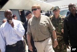 This photo provided by the Dutch Defense Ministry shows Dutch King Willem-Alexander, center, visiting after the passing of Hurricane Irma, in Dutch Caribbean St. Maarten, Sept. 11, 2017.