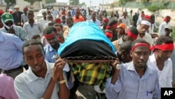 Somali journalists carry the slain body of their colleague, Abdisalan Sheikh Hasan, during his funeral in southern Mogadishu, Somalia, December 19, 2011.