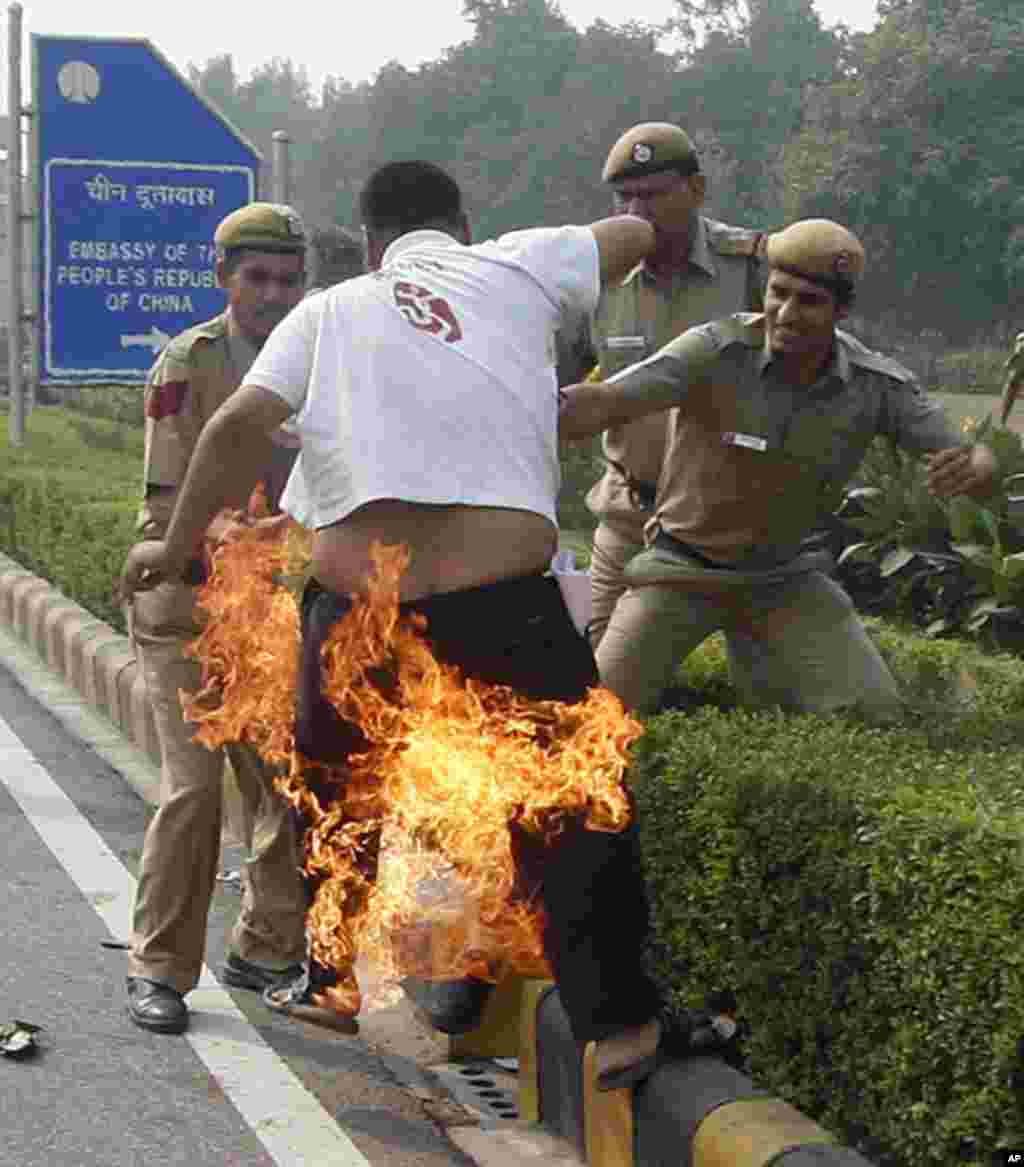 Police try to douse flames on a Tibetan demonstrator after he tried to self immolate himself during a protest in front of the Chinese embassy in New Delhi. Tibetan exiles on protested the deaths of several ethnic Tibetans by self immolation in Tibetan are