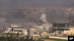 This frame grab from video provided by the government-controlled Syrian Central Military Media, shows smoke rising during fighting between insurgents and Syrian government troops, in an eastern neighborhood of Damascus, Syria, March. 22, 2017. 