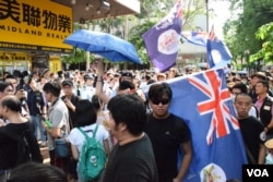 部份示威者高舉殖民時期的港英旗幟。(美國之音湯惠芸)