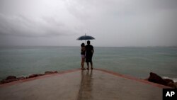 FILE - A couple looks out to sea as rainfall increases on the Pacific coast near Puerto Vallarta, Mexico, Oct. 23, 2015. A tropical depression formed off Mexico's southern Pacific coast Wednesday, prompting authorities to issue a tropical storm warning.