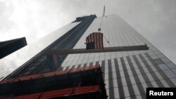 Una viga con la bandera de Estados Unidos es colocada en lo alto de la torre 4 del World Trade Center, en Nueva York.