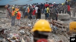 FILE - Rescue workers are seen on the site of a collapsed building in Lagos, Nigeria, Sept. 16, 2014.