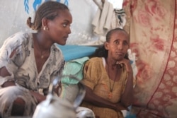 Ageza Neba, right, and her daughter, Ksana Giday, fled the conflict in Ethiopia, leaving behind loved ones, including Neba’s son. Dec. 10, 2020, in the Um Rakouba camp in Sudan. (Mohaned Bilal/VOA)