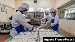 Employees produce wheat cakes stuffed with meat at the Kumsong Foodstuff Factory in Pyongyang on Sept. 24, 2021.
