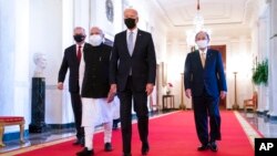 President Joe Biden walks to the Quad summit with, from left, Australian Prime Minister Scott Morrison, Indian Prime Minister Narendra Modi, and Japanese Prime Minister Yoshihide Suga, in the East Room of the White House, Sept. 24, 2021.