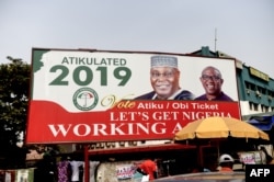 A billboard with a campaign poster bearing images of the opposition Peoples Democratic Party election candidate Atiku Abubakar and his running mate Peter Obi stands on a road in Abuja, Nigeria, Feb. 19, 2019.