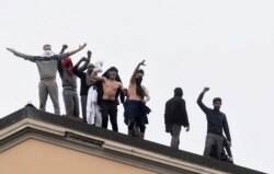 Inmates are seen on the roof of the San Vittore Prison during a revolt after family visits were suspended due to fears over coronavirus contagion, in Milan, Italy