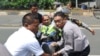 مردم در حال حمل یک پلیس مجروح در جاکارتا در روز پنجشنبه