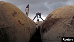 FILE - Children play on pontoons as clouds gather over the banks of the river Ganges in Allahabad, India.