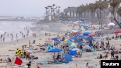 People gather at the beach to cool-off as a heatwave continues in Oceanside, California, U.S., June 17, 2021. REUTERS/Mike Blake