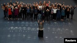 Cuban artist Tania Bruguera stands in the middle of her Hyundai Commission, Our Neighbors, artwork in the the Turbine Hall of Tate Modern, in London, Britain, Oct. 1, 2018. Volunteers stand behind her after lying down on the heat sensitive artwork.