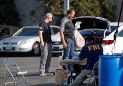 Federal agents work at a downtown Los Angeles parking lot after predawn raids, Aug. 22, 2019.
