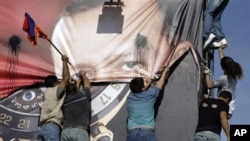 Lebanese of Armenian descent carry an Armenian flag as they tear up a poster showing Turkish Prime Minister Recep Tayyip Erdogan during a protest against his visit, in Beirut's Martyrs' Square, Lebanon, 25 Nov 2010