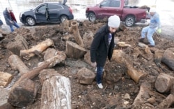 People collect firewood on a wood heap opened to the public to enable them to heat their homes after widespread power outages left them in the cold, in Dallas, Texas, Feb. 17, 2021.
