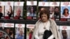 A woman pauses near posters of hostages held by Hamas in the Gaza Strip, in Tel Aviv, Israel, as Israel's security Cabinet convened, Jan. 17, 2025.